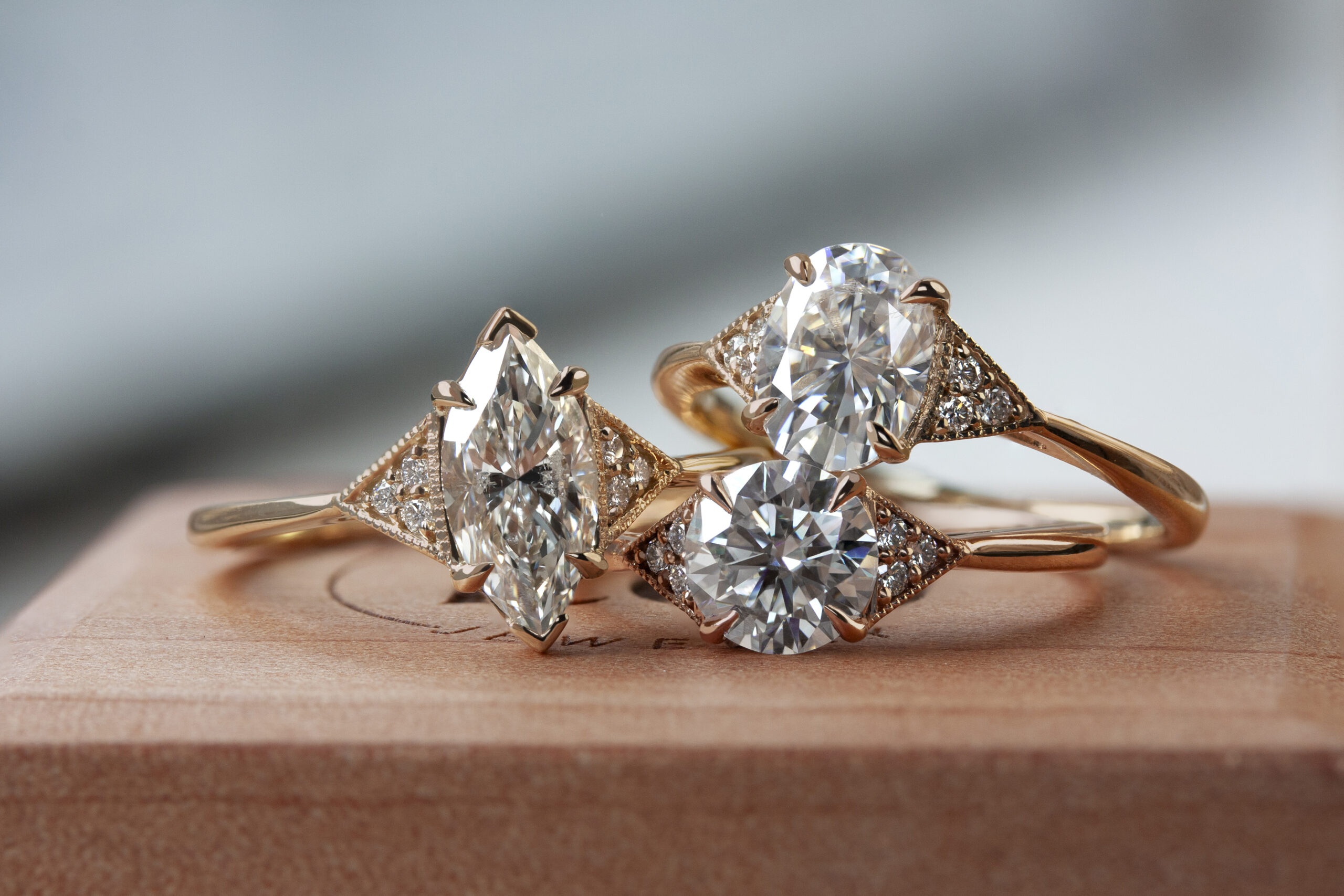 Three custom June Rings by Philadelphia's Emily Chelsea Jewelry, showcasing timeless designs, delicate sparkle, and white center diamonds.