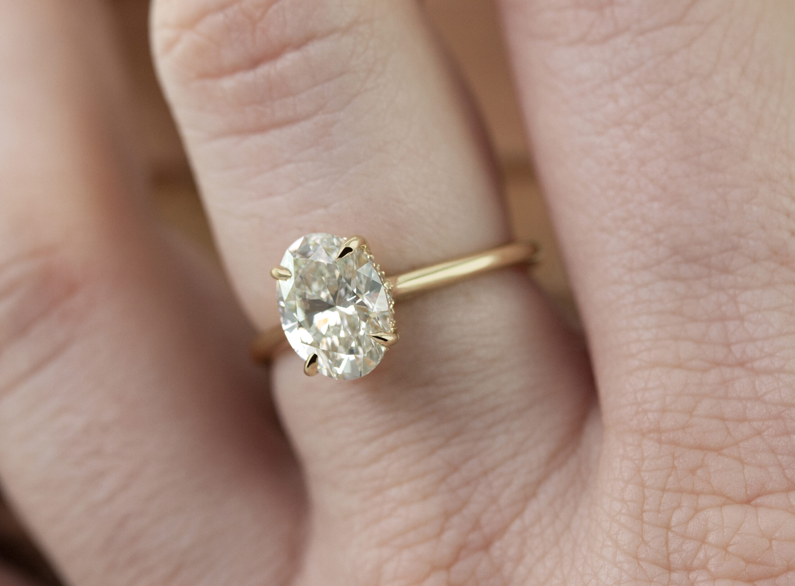 Solitaire dawn oval ring by Philadelphia local jeweler Emily Chelsea Jewelry, featuring a hidden halo, reclaimed diamonds, and a 2mm band.