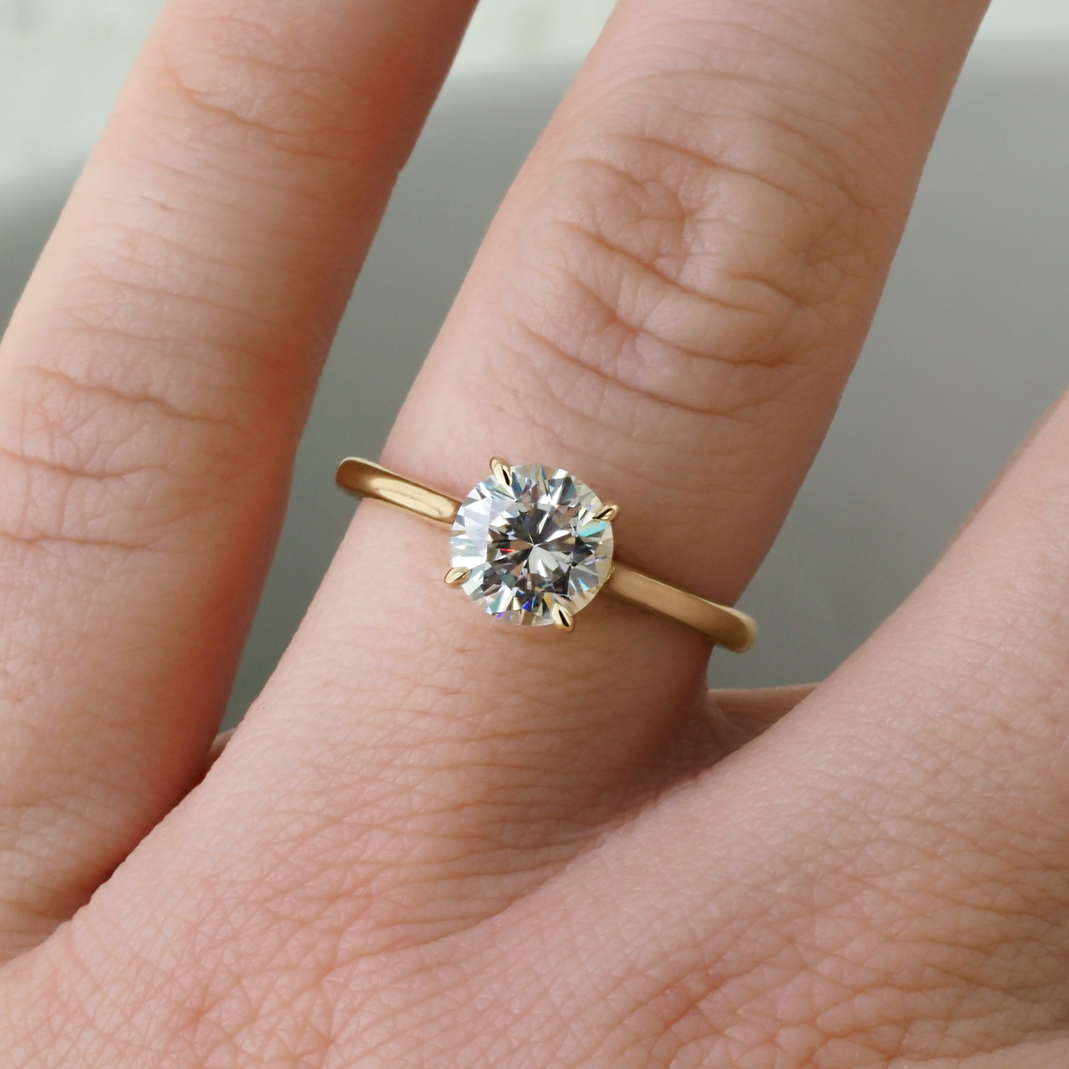 Timeless solitaire dawn ring by Philadelphia local jeweler Emily Chelsea Jewelry, featuring a hidden halo, reclaimed diamonds, and a 2mm band.