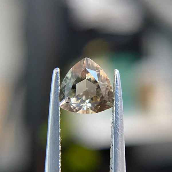 0.61ct trillion-cut greenish peach Oregon sunstone, 6.03mm x 6.05mm. Softer gem at 6-6.5 Mohs. Emily Chelsea Custom Jeweler in Philadelphia.