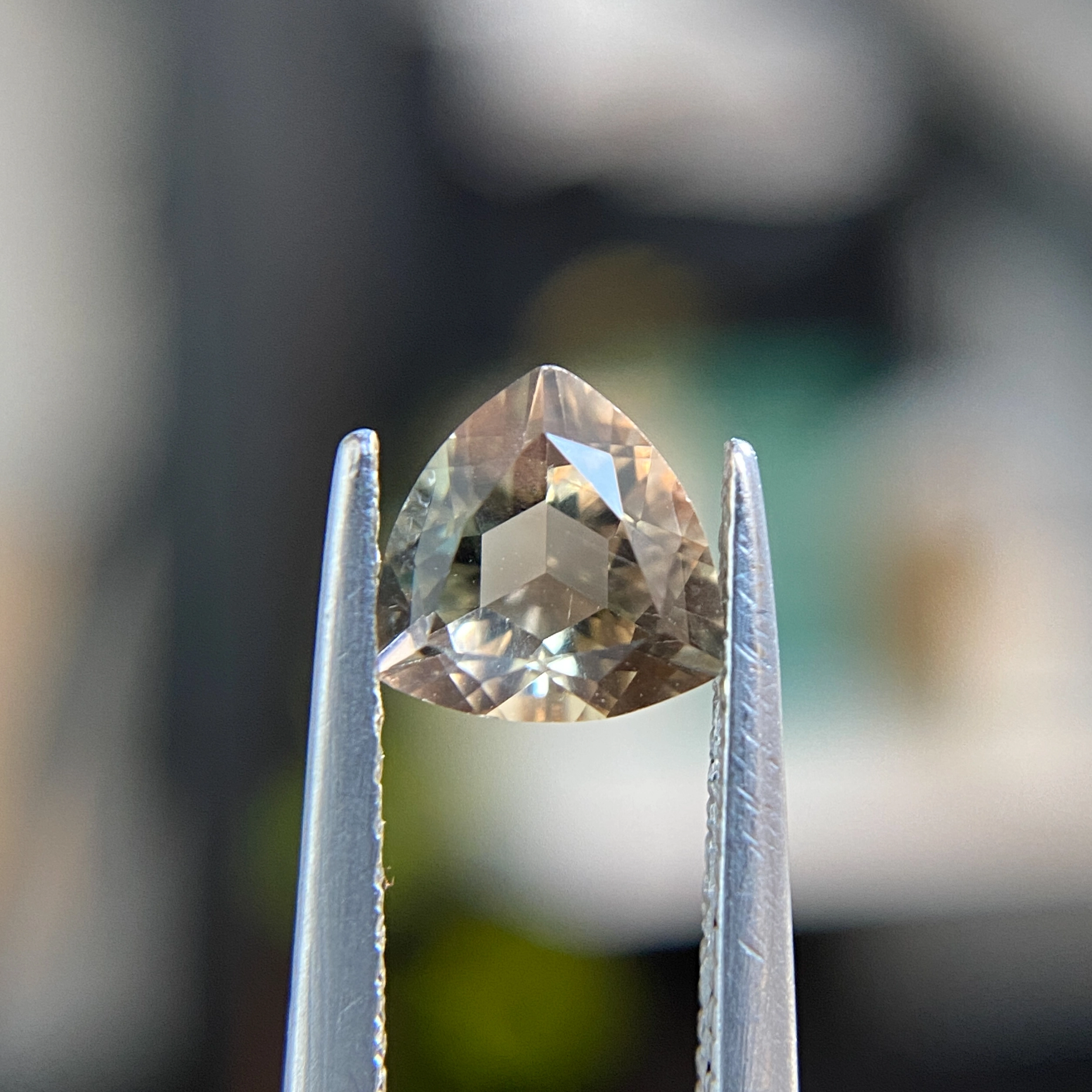 0.61ct trillion-cut greenish peach Oregon sunstone, 6.03mm x 6.05mm. Softer gem at 6-6.5 Mohs. Emily Chelsea Custom Jeweler in Philadelphia.