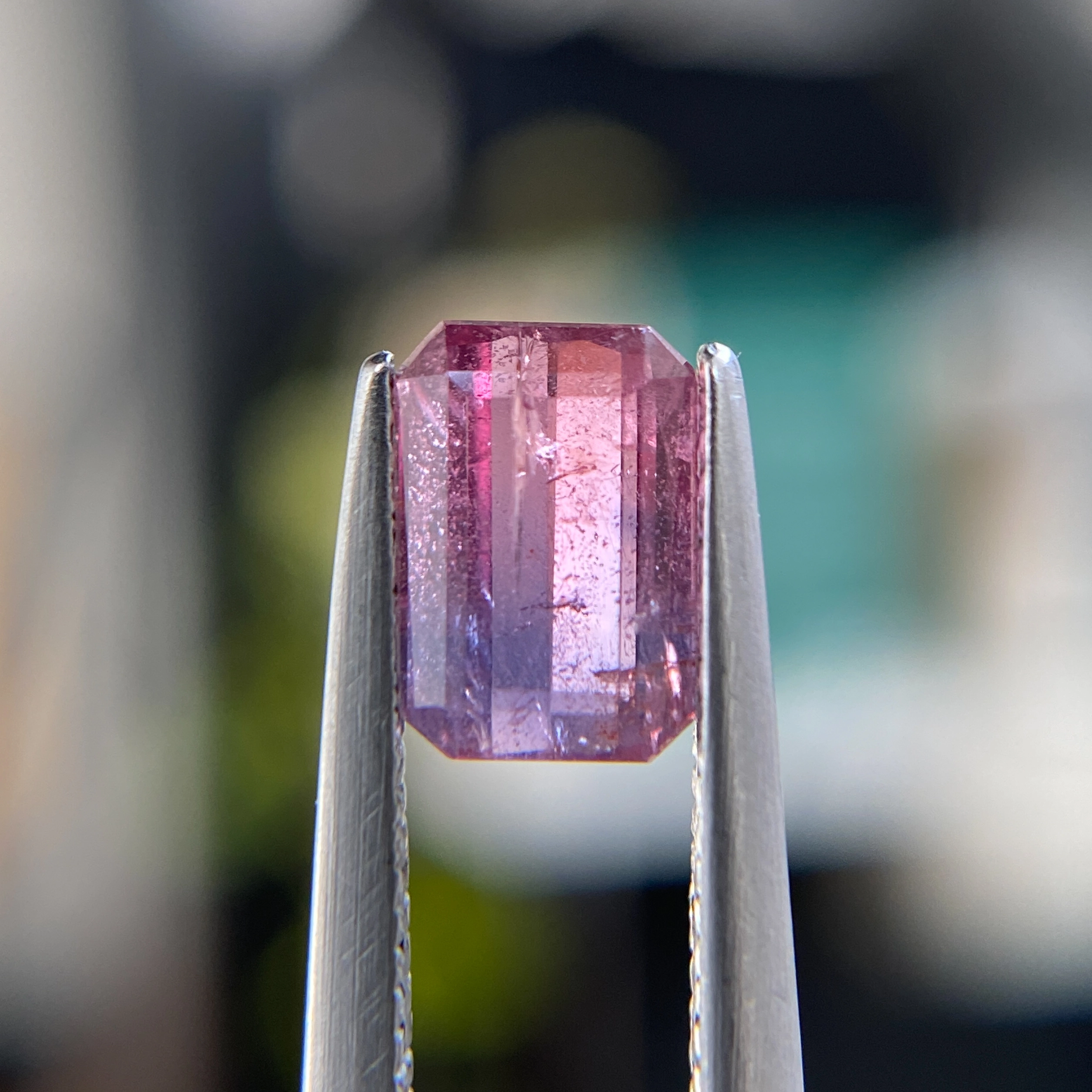 1.23ct unheated emerald-cut orangish pink and purple Winza sapphire, 6.92mm x 4.77mm. Rare color-zoned gem. Emily Chelsea Custom Jeweler in Philadelphia.