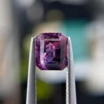 1.36ct unheated emerald-cut orangish pink and purple Winza sapphire, 6.24mm x 5.35mm. Rare color-zoned gem. Emily Chelsea Custom Jeweler in Philadelphia.