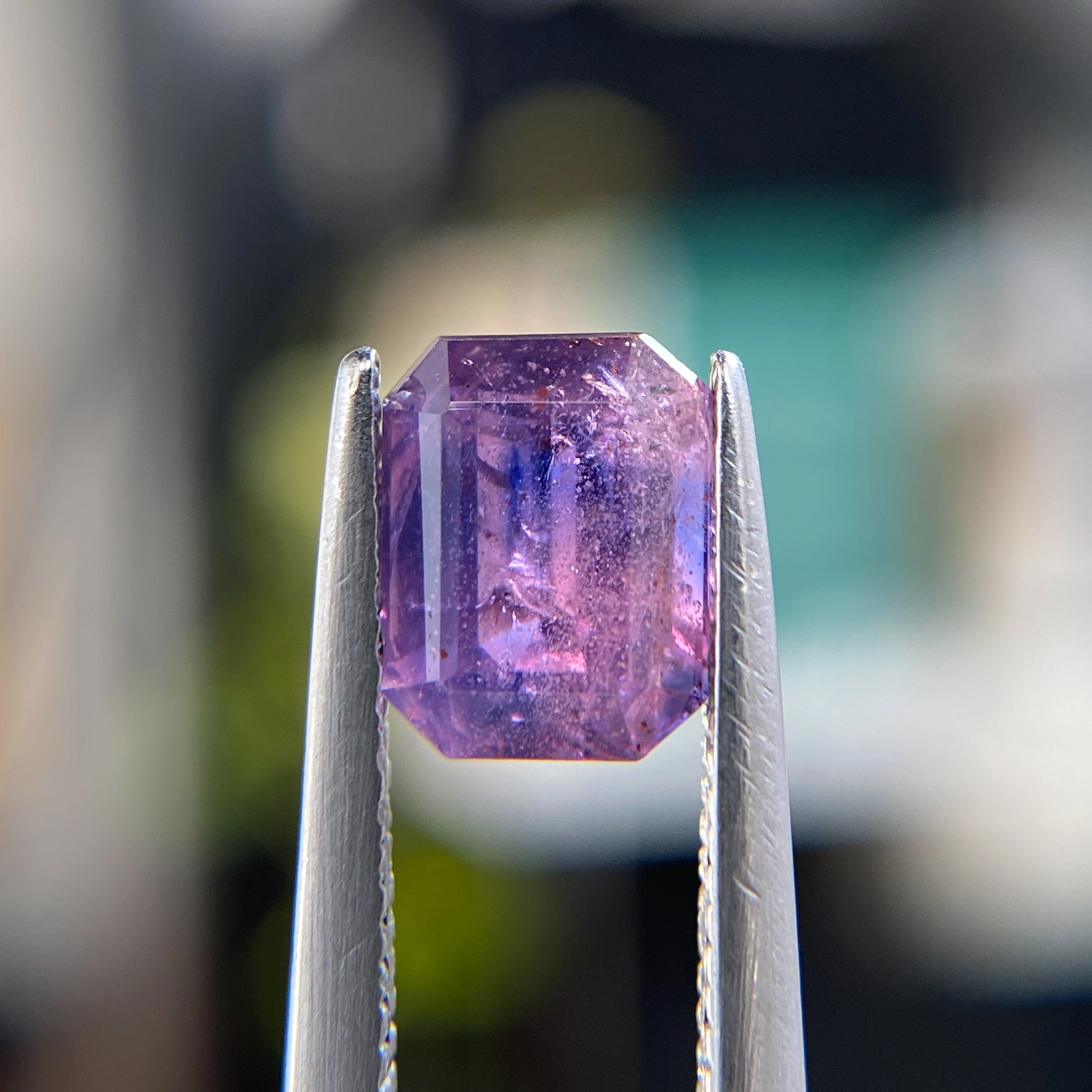 1.58ct unheated emerald-cut pink, orange, and purple Winza sapphire, 6.88mm x 5.42mm. Rare color-zoned gem. Emily Chelsea Custom Jeweler in Philadelphia.