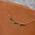 Arc Necklace by Philadelphia’s Emily Chelsea Jewelry, featuring Indian moss agate, Nigerian green tourmaline, and a gracefully curved design.