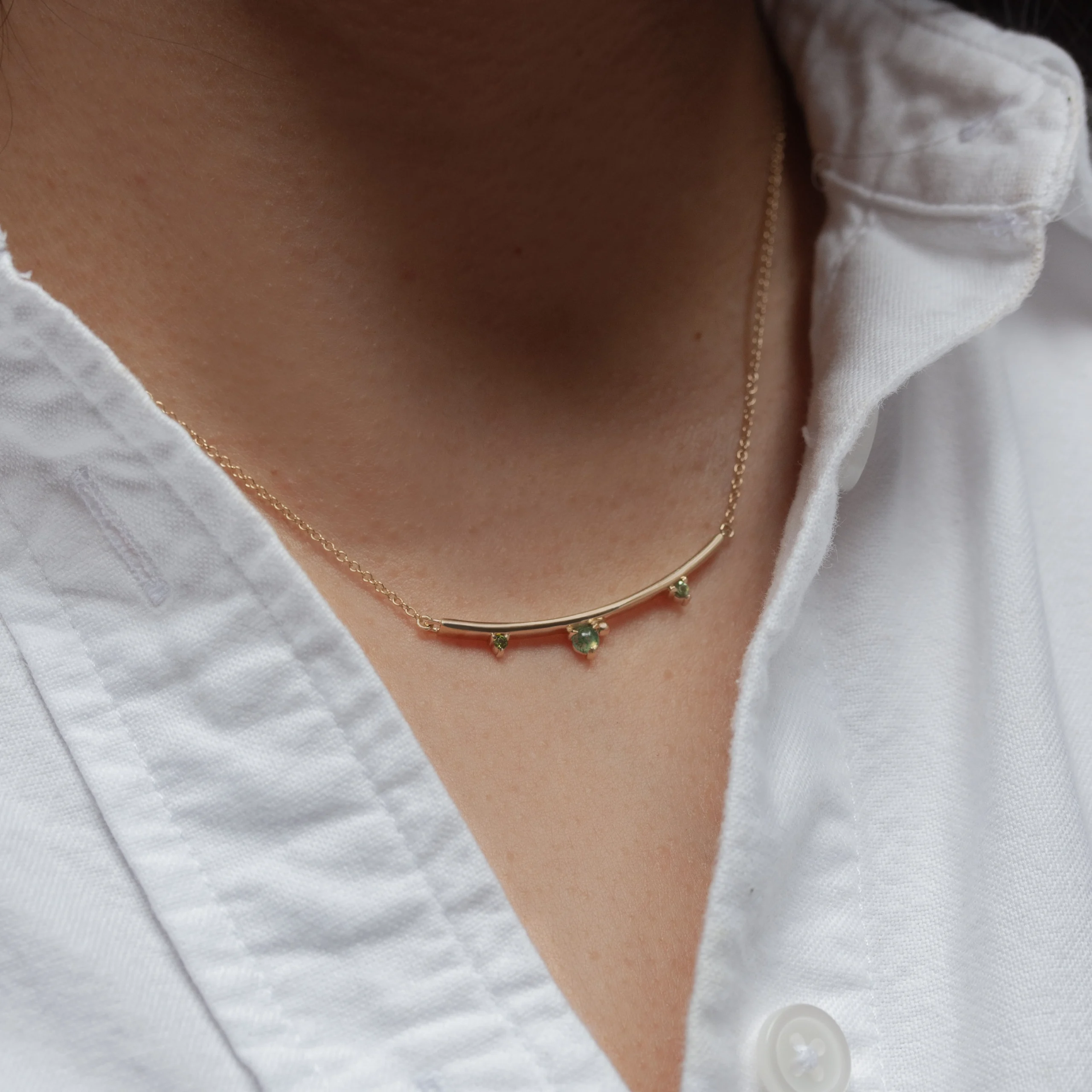 Arc Necklace by Philadelphia’s Emily Chelsea Jewelry, featuring Indian moss agate, Nigerian green tourmaline, and a gracefully curved design.