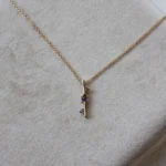 Through It All Necklace by Philadelphia’s Emily Chelsea Jewelry, featuring amethyst, spinel, and a symbolic interrupted bar motif.