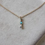 Through It All Necklace by Emily Chelsea Jewelry, a custom design with Arizonian turquoise, Nigerian teal tourmaline, and an interrupted metal bar motif symbolizing resilience.