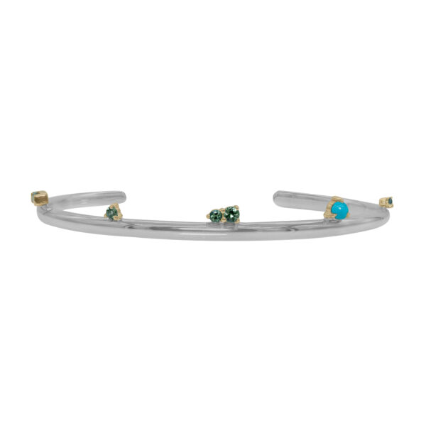 The Silver Lining Cuff from Emily Chelsea Jewelry features Arizonian turquoise, Nigerian teal tourmaline, and a polished finish. A perfect piece to add to your stack.