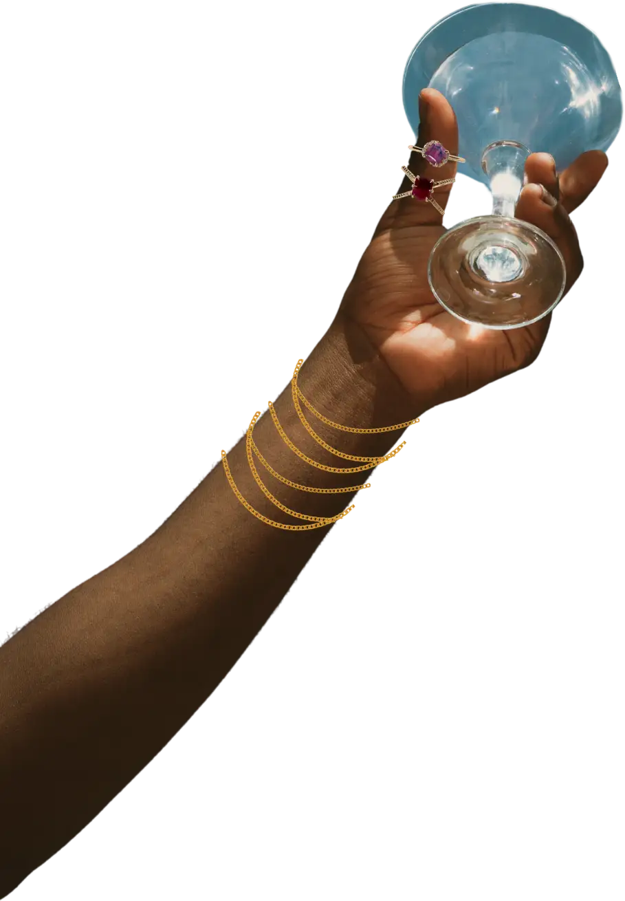 Emily Chelsea bracelets and ring on hand holding a cocktail glass